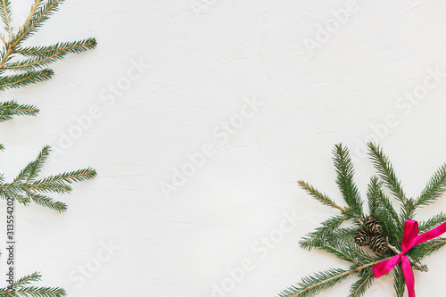 Christmas composition. Green Christmas tree on a white background with a red ribbon. Flat lay, top view.