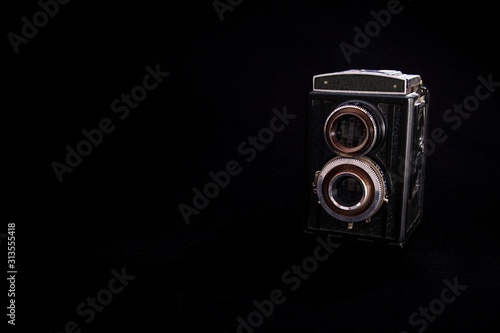 Retro camera on black background, isolated object