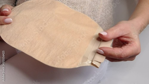 Colostomy bag, supply needed after colostomy surgery - colon cancer treatment. 2 piece ostomy bag in skin color. Medical theme. Stoma bag ready to use photo