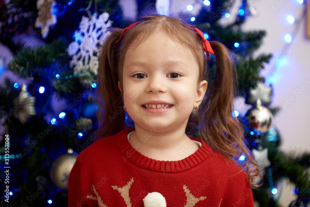 Cute little girl on the background of the Christmas tree Cute little girl on the background of the Christmas tree