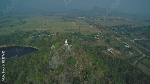 Wallpaper Mural VDO. Aerial view flying around white pagoda on top hill 360 degree, around with soft mist and cloudy sky background. Pagoda no name in Ratchaburi, west of Thailand. Torontodigital.ca