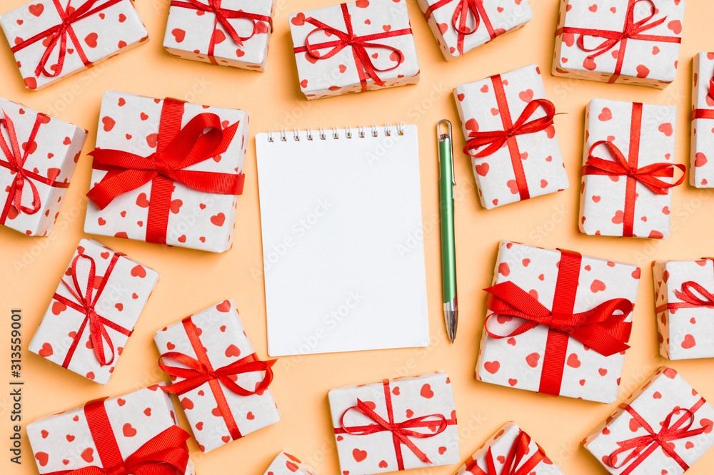Holiday composition of notebook and gift boxes with red hearts on colorful background with empty space for your design. Top view of Valentine's Day concept Holiday composition of notebook and gift boxes with red hearts on colorful background with empty space for your design. Top view of Valentine's Day concept