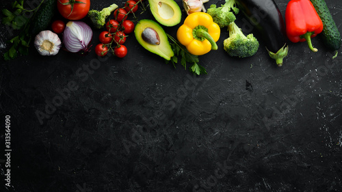 Ripe vegetables. Fresh vegetables on black stone background. Tropical fruits. Top view. Free space for your text.