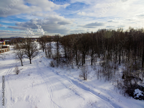 Bird's-eye view of the city and forest in snowy winter.