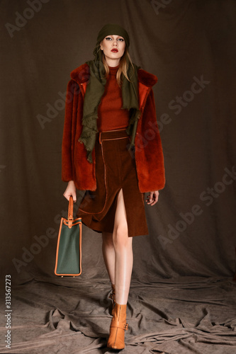 girl in a beautiful brown fur coat posing in the Studio on a brown background