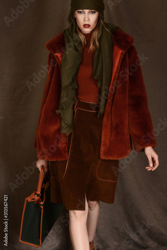 girl in a beautiful brown fur coat posing in the Studio on a brown background