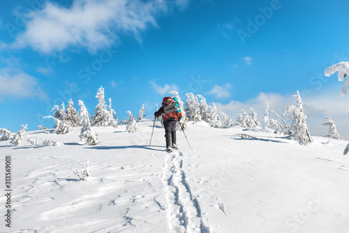 Man hiking on snow in winter mountains