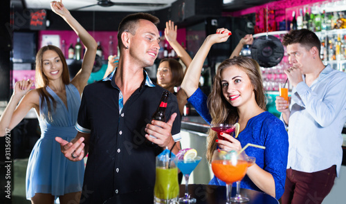 Man with woman are drinking cocktails on corporate party.