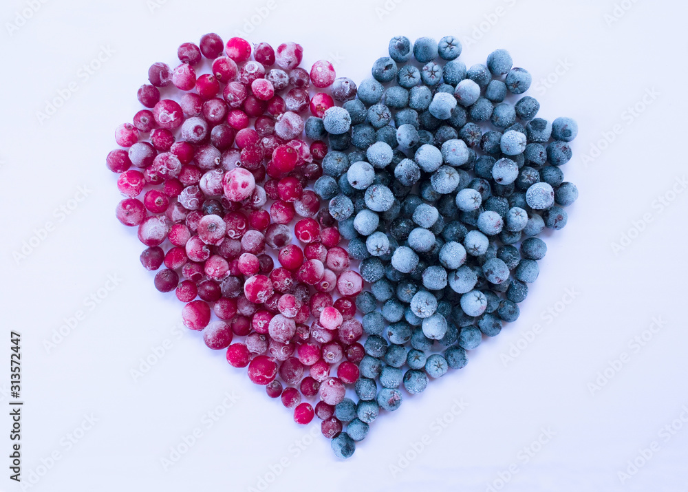 Big heart made from frozen cranberry and chokeberry berries on a white background. Healthy food concept. Big heart made from frozen cranberry and chokeberry berries on a white background. Healthy food concept.