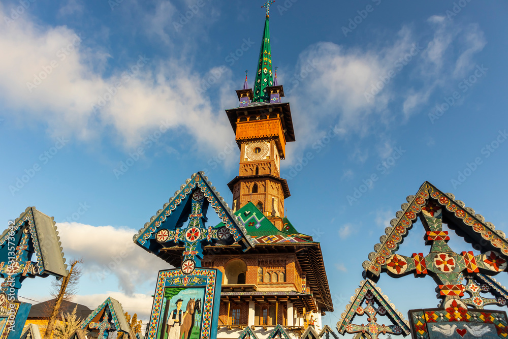 Obraz premium Colorful, painted wooden crosses at Merry Cemetery of Sapanta. Tombstone vivid colors pictures. Paintings on the wooden crosses
