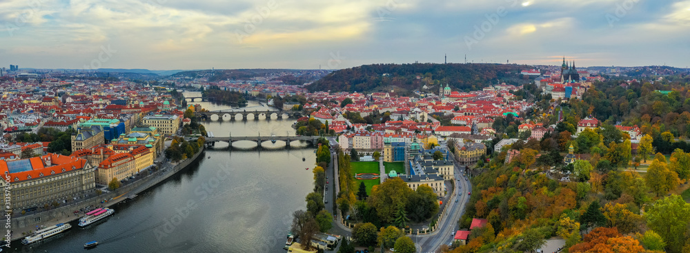 Obraz premium Aerial Prague panoramic drone view of the city of Prague at the Old Town Square, Czechia. Prague Old Town pier architecture and Charles Bridge over Vltava river in Prague at sunset, Czech Republic.