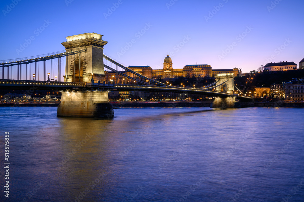 Budapest iconic Chain Bridge by night over the Danube River with the Royal Palace and the President's Palace