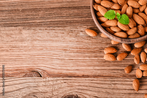 Almond nuts on wooden table top view. Fresh almonds copy space.