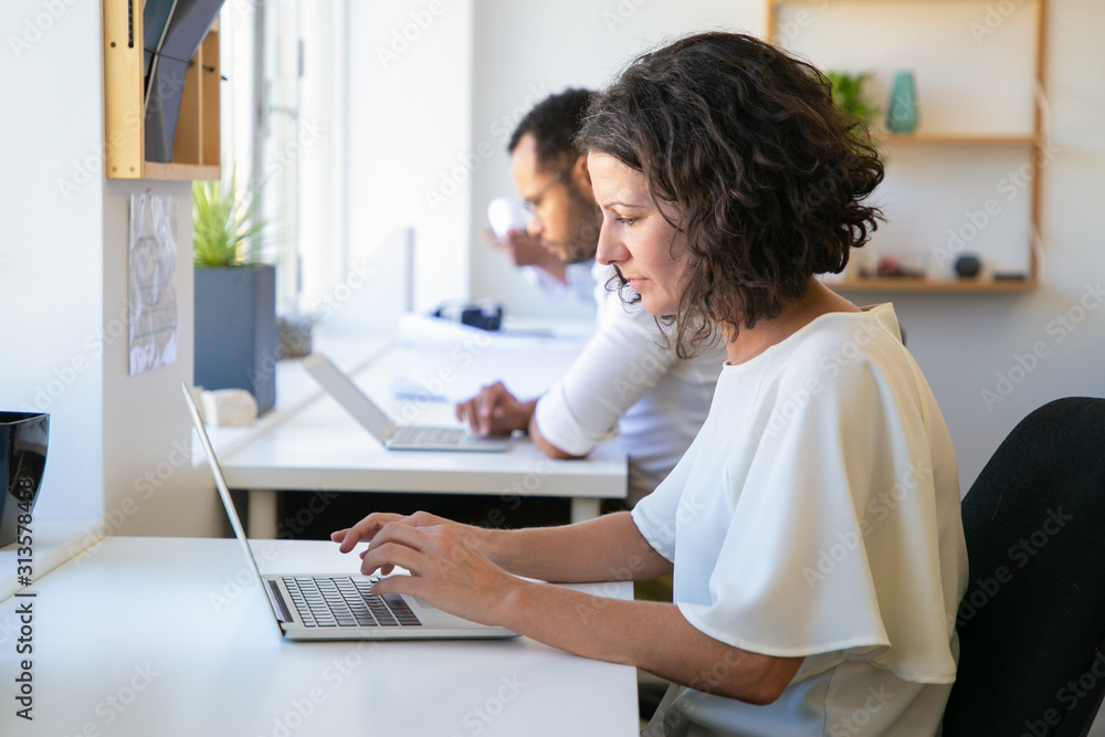 Tired Caucasian woman working with laptop. Annoyed mature woman using laptop at office. Technology concept Tired Caucasian woman working with laptop. Annoyed mature woman using laptop at office. Technology concept
