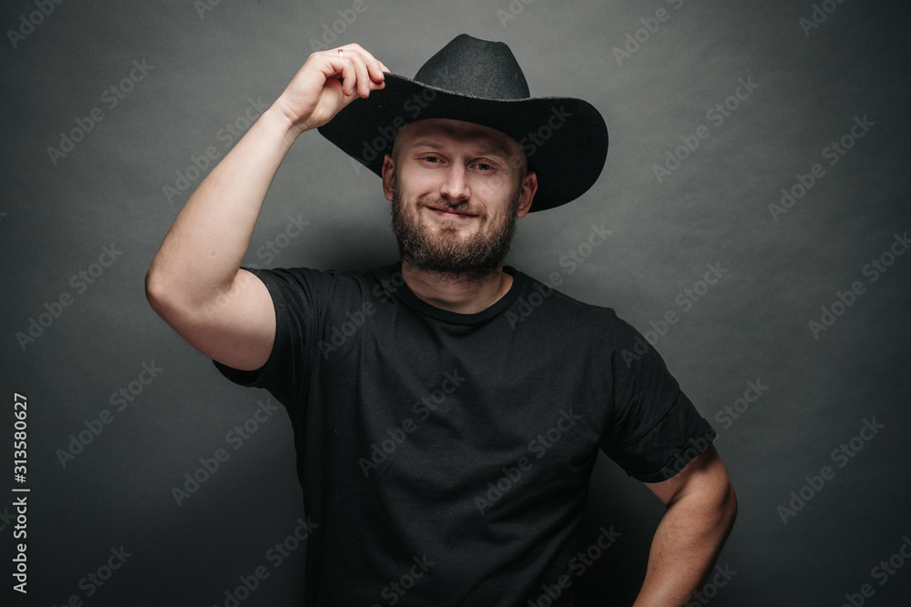 Handsome cowboy wearing black cowboy hat with beard Stock Photo Adobe