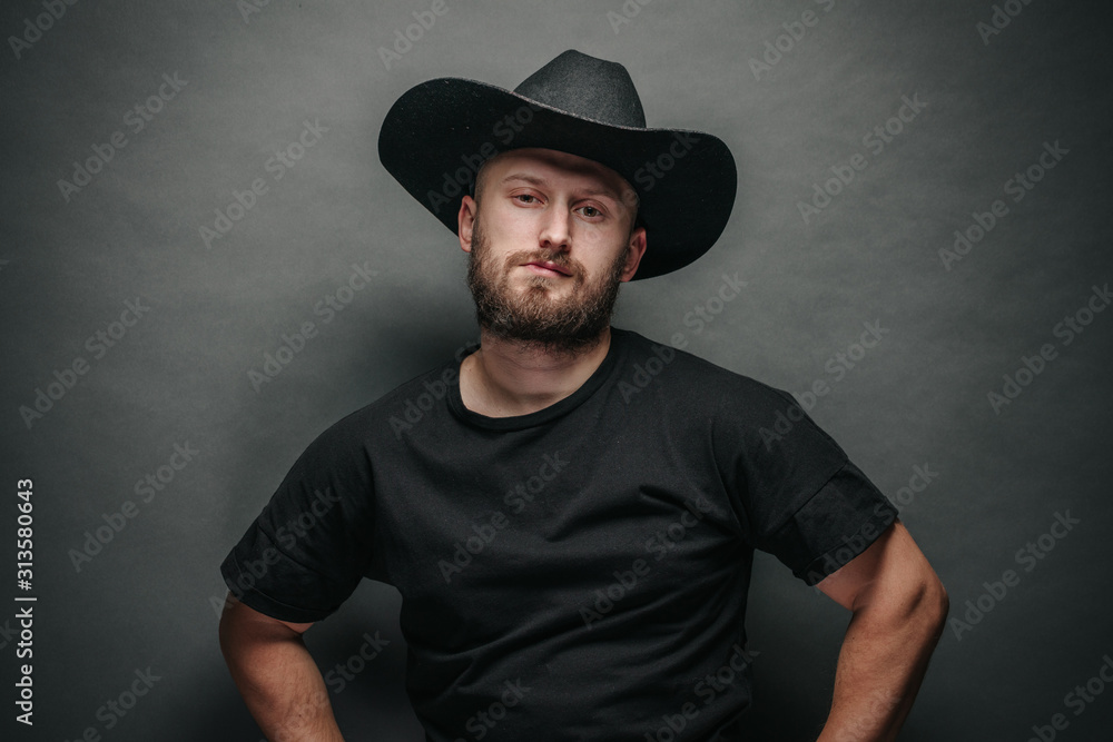 Handsome cowboy wearing black cowboy hat with beard Handsome cowboy wearing black cowboy hat with beard