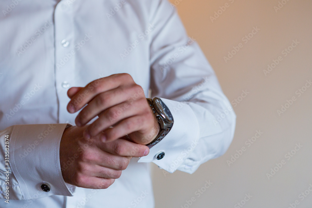 groom's dress and wedding preparation. helping the groom get dressed, put on his watch, shoes, tie, bow tie and jacket. groom's dress and wedding preparation. helping the groom get dressed, put on his watch, shoes, tie, bow tie and jacket.