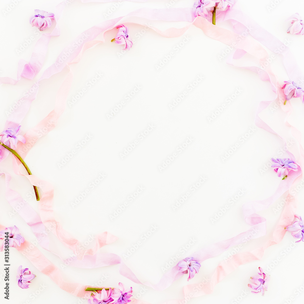 Floral frame of hyacinth flowers, petals and tapes on white background. Flat lay