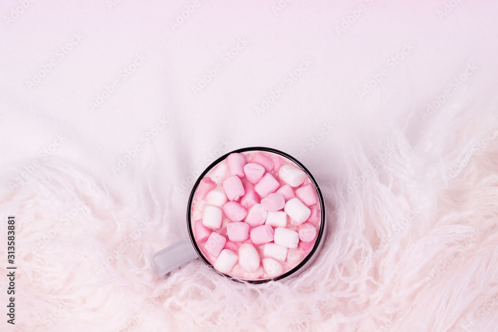 Cup of coffee with pink marshmallow on bed with warm plaid. Copy space. Flat lay, top view Cup of coffee with pink marshmallow on bed with warm plaid. Copy space. Flat lay, top view