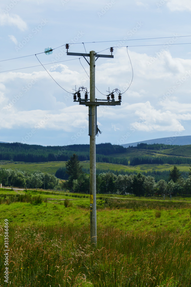 Strommast auf Wiesen, Felder und Hügel, bei Ledmore, in den Highlands von Schottland