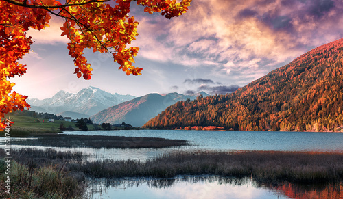 Wonderful Alpine Landscape in Sunny day. Colorful Autumn scene. Picture of wild area. Stunning Scenery during sunset  Fantastic Colorful clouds over the mountain lake in alps.