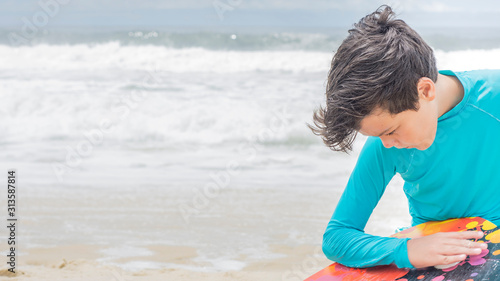  surfer boy preparing surf board