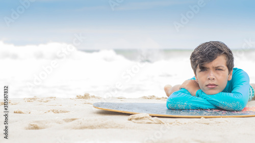 surfer boy lying on the board 