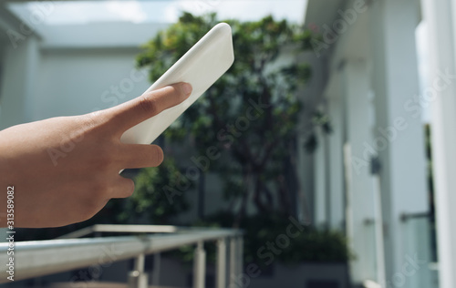 Woman holding white smartphone outside