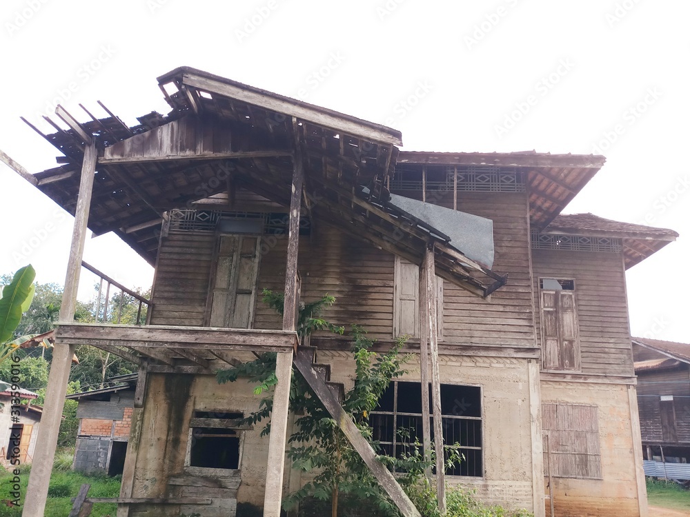 old house with roof.The old two-story gray house, the top floor is wood, the bottom is stone. vintage house. old house with roof.The old two-story gray house, the top floor is wood, the bottom is stone. vintage house.
