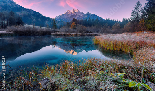 Awesome Alpine Valley during sunset with majestic mountain peak on background Scenic image of nature at lake Zelenci in autumn. Zelenci nature reserve. Triglav national park. Kranjska Gora, Slovenia photo