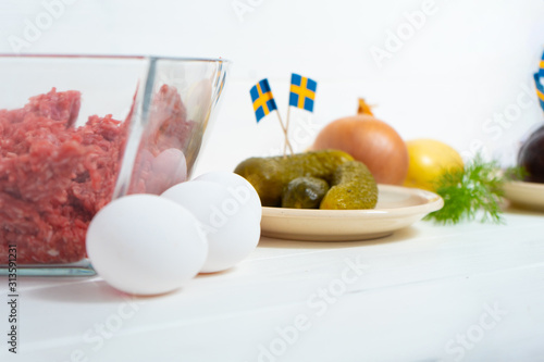 Ingredients for a traditional Swedish dish beef Lindstrom. Freshly minced beef, boiled potato, white chopped onion, pickles, pickled red beets, eggs. Swedish cuisine. Scandinavian cuisine. photo