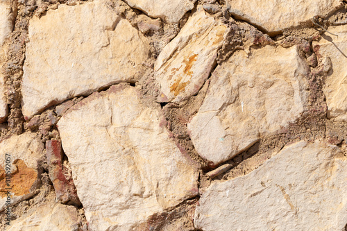 Background of limestone masonry. The surface is decorated with natural material. The wall is made of wild stone.