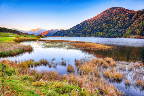 Splendid autumn panorama of Haidersee (Lago della Muta) lake with Ortler peak on backgroun
