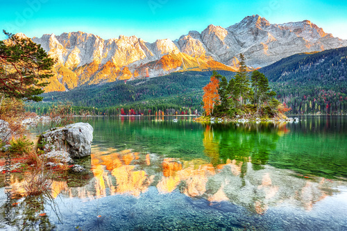Charming autumn landscape of islands with pine-trees in the middle of Eibsee lake.