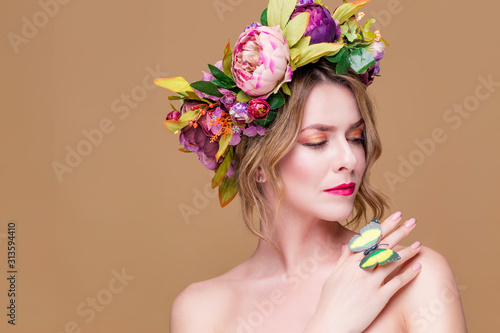 tender young woman posing in flower wreath with artificial  greenbutterfly,  isolated on ochet background photo