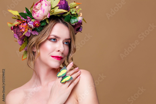 tender young woman posing in flower wreath with artificial  greenbutterfly,  isolated on ochet background photo