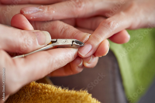 Nail care service at salon  removing cuticle with nail nipper 