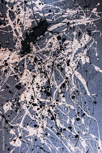 Picture painted using the technique of dripping. Mixing different colors white and black. Lines and spots. Vertical orientation.