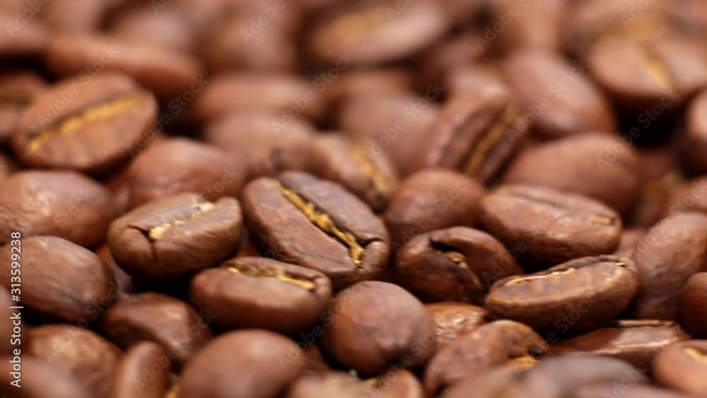 Fragrant coffee beans scrolls slowly around the camera. Coffee beans roasted rotating blurry background close up. Fragrant coffee beans scrolls slowly around the camera. Coffee beans roasted rotating blurry background close up.