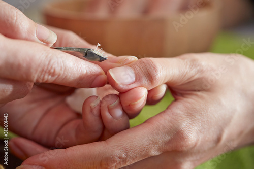 Nail care service at salon  removing cuticle with nail nipper 