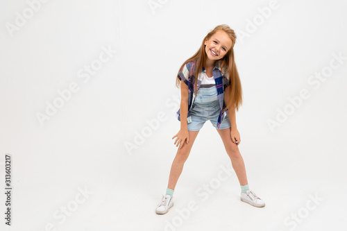 Caucasian teenager girl in denim jacket and shorts rejoices isolated on white background