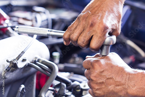 maintenance car using screwdriver. dirty man hands holding tools fixing repair car engine.