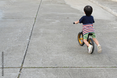 cute boy riding balance bike on street have fun