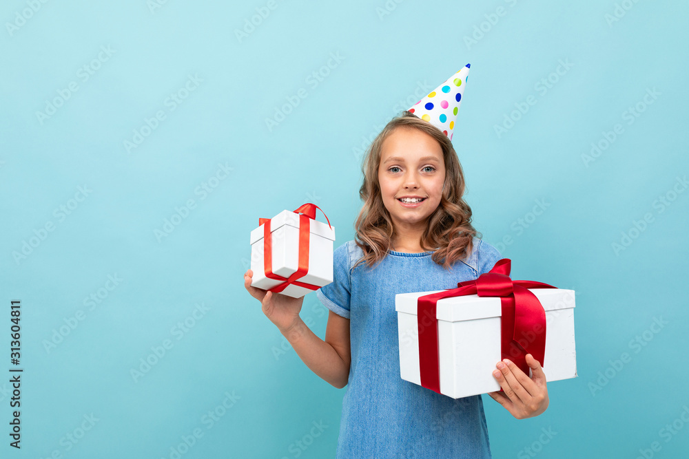 girl with a holiday hat holds her gifts on a studio background girl with a holiday hat holds her gifts on a studio background