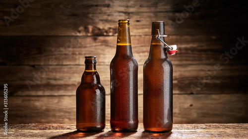 Otwarte butelki piwa na tle starych desek