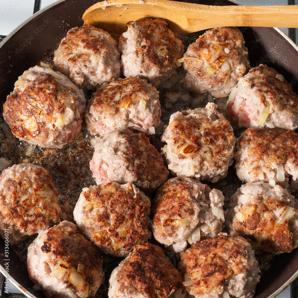 Fried meat large meatballs in a pan on a gas stove, close-up Fried meat large meatballs in a pan on a gas stove, close-up