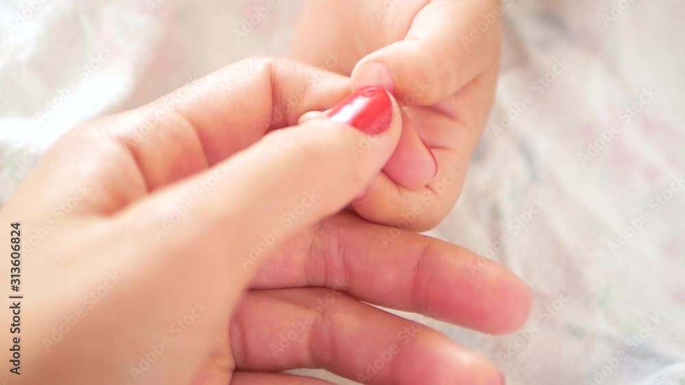 Mom strokes the hand of a newborn baby. Close-up of mom holding his baby fingers. mother strokes the finger of her newborn baby. the mother gently strokes the tiny little arms of her newborn baby. Chi Mom strokes the hand of a newborn baby. Close-up of mom holding his baby fingers. mother strokes the finger of her newborn baby. the mother gently strokes the tiny little arms of her newborn baby. Chi
