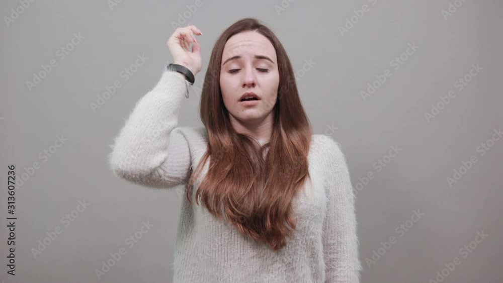 Surprised attractive caucasian woman keeping hand on head, corrects haircut wearing nice clothes isolated on gray background in studio. People emotions, lifestyle concept. Surprised attractive caucasian woman keeping hand on head, corrects haircut wearing nice clothes isolated on gray background in studio. People emotions, lifestyle concept.