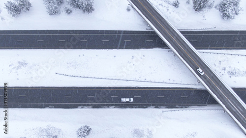 TOP DOWN: Flying over a highway overpass in USA during an intense blizzard.