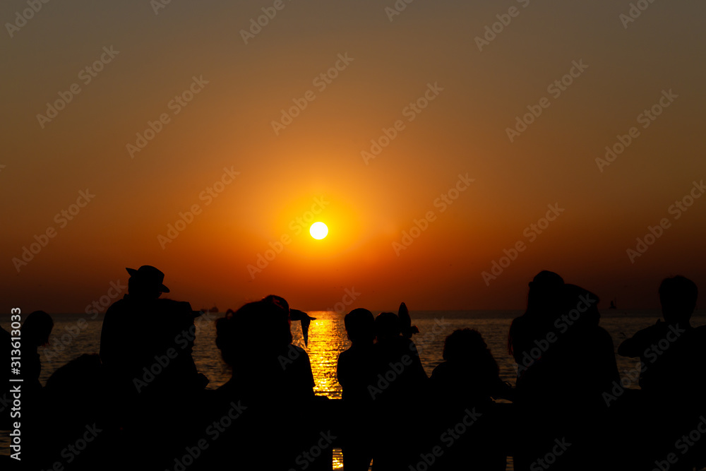 Fototapeta premium silhouette people taking seagull photo with sunset at Bang Pu Resort, Thailand. decoration image contain certain grain noise and soft focus.